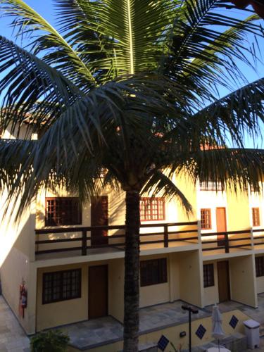 a palm tree in front of a building at Hotel da Ilha in Ilhabela