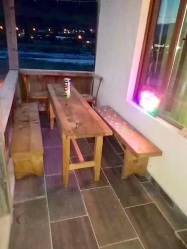 a wooden table and benches in a room with a window at Apartment Jorjo Mestia in Mestia