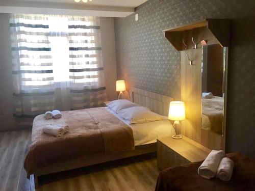 a bedroom with two beds and a mirror at Apartment Jorjo Mestia in Mestia