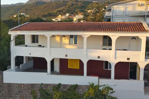 une grande maison blanche avec un toit rouge dans l'établissement Diamond by EXCLUSIVE Collection Sea view apartments, à Dobra Voda