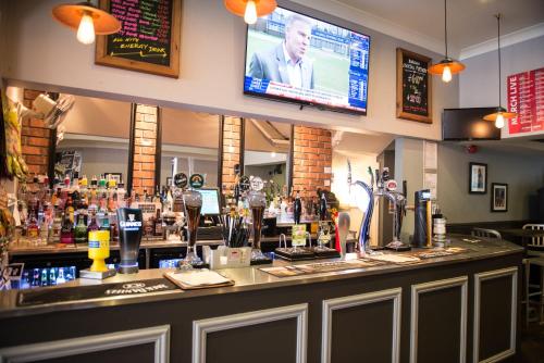 um bar num restaurante com uma televisão por cima em Thomas James Hotel em Leamington Spa