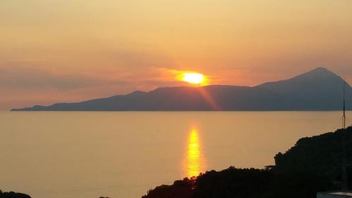 a sunset over the water with a mountain in the background at B&B nonnAngela in Maratea