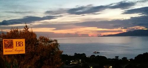 a sign with a boat in the water at sunset at B&B nonnAngela in Maratea