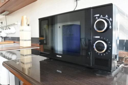 a microwave oven sitting on top of a counter at APARTMÁN V ZAHRADĚ PRAHA TROJA - APARTMENT IN THE GARDEN PRAGUE Troja in Prague