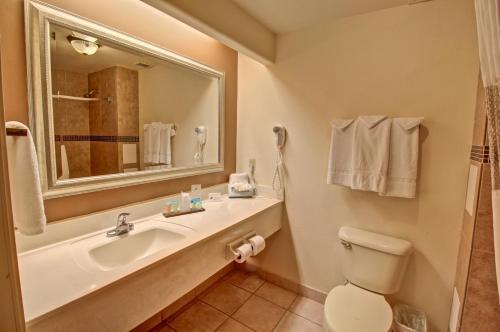 a bathroom with a sink and a toilet and a mirror at The Inn at South Padre in South Padre Island