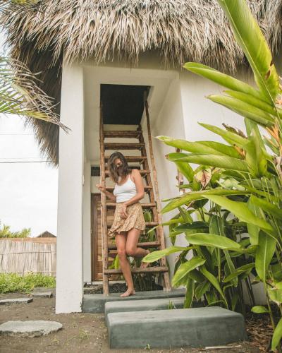 a woman standing on a ladder outside of a house at Swell in El Paredón Buena Vista
