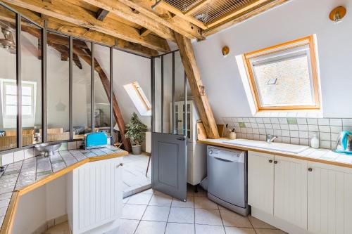 a large kitchen with white cabinets and a window at VillaConcorde in Amboise