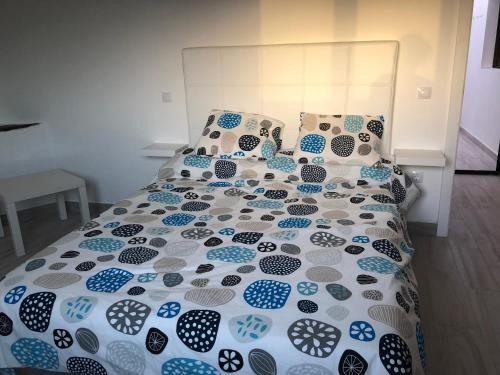 łóżko z niebiesko-białą kołdrą i poduszkami w obiekcie Yasmina w mieście Lajares