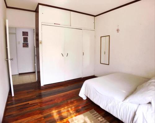 a bedroom with a white bed and white cabinets at Casa Kibi Kibi in San José