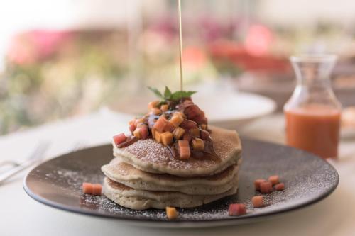 a plate with a stack of pancakes with carrots on top at Grand Miramar All Luxury Suites & Residences in Puerto Vallarta