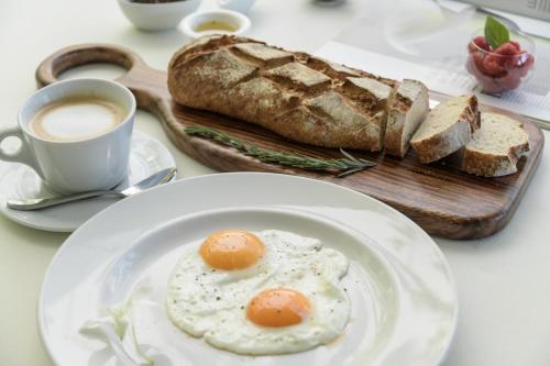 a plate of eggs and bread and a cup of coffee at Grand Miramar All Luxury Suites & Residences in Puerto Vallarta