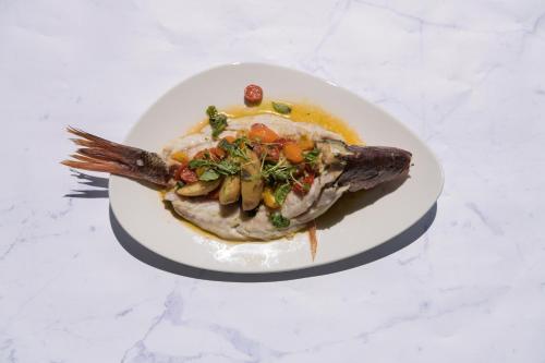 a plate of food with a fish on a table at Grand Miramar All Luxury Suites & Residences in Puerto Vallarta