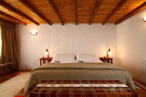 a bedroom with a large bed with two night stands at Casa De Piedra in Purmamarca