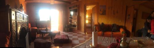 ein Wohnzimmer mit einem Tisch und einem Fenster in der Unterkunft Chalet tizrag in Oukaïmeden