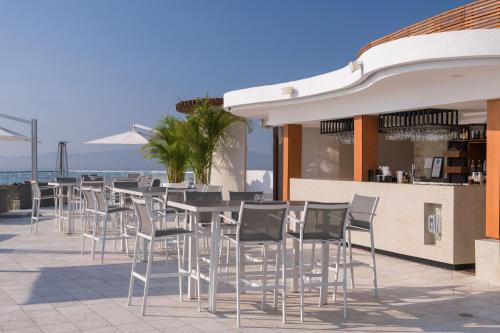 a row of tables and chairs on a patio at Grand Miramar All Luxury Suites & Residences in Puerto Vallarta