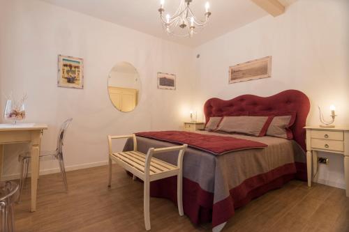una camera da letto con un letto grande con testiera rossa di Villa Goccia di Vino a La Morra