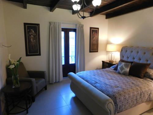 una camera con un letto blu e un divano di Hotel Boutique Rancho San Jorge a Bernal