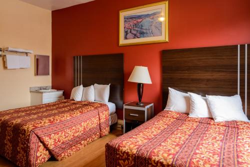 two beds in a hotel room with red walls at Europa Hotel in San Francisco