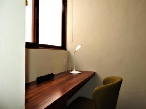 a desk with a lamp and two chairs in front of a window at Villas La Ceiba in Playa del Carmen