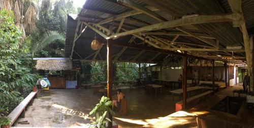 a large building with a roof with tables and chairs at Villa Hermosa de Tambopata Casa Hospedaje & Hostel in Puerto Maldonado