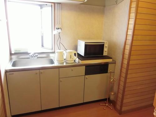 cocina con fregadero y microondas en Minpaku Nagashima room1 / Vacation STAY 1028 en Kuwana