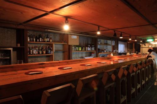 a bar with a long wooden counter in a restaurant at Canadian Village Goryu in Hakuba