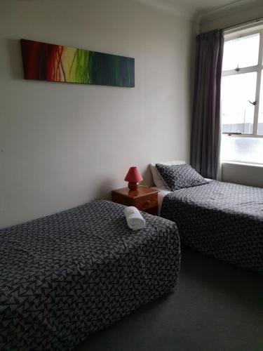 a hotel room with two beds and a window at Horse and Jockey Inn in Matamata