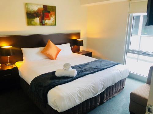 a bedroom with a large white bed with orange pillows at Adara St Kilda in Melbourne