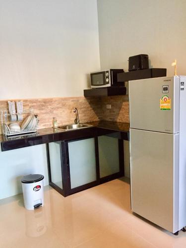 a kitchen with a refrigerator and a sink at Baan Fran Sim Da in Bang Tao Beach