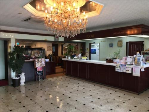 a large lobby with a chandelier and a counter at Sunrise Hotel Okinawa-どこか懐かしいレトロな雰囲気の宿 in Okinawa City