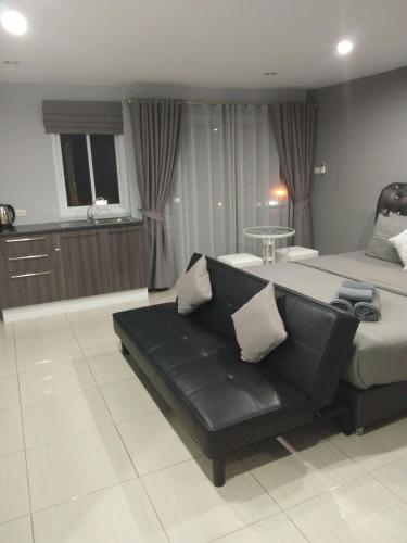 a living room with a bed and a couch at Asia's Beach Apartments in Sattahip