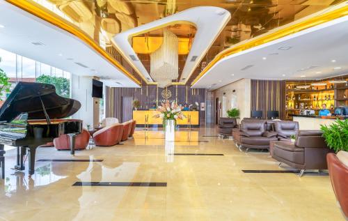 a lobby with a grand piano and chairs at Grand Gold Hotel in Danang