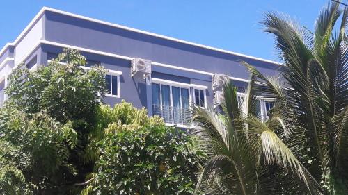 a white building with trees in front of it at Asia's Beach Apartments in Sattahip