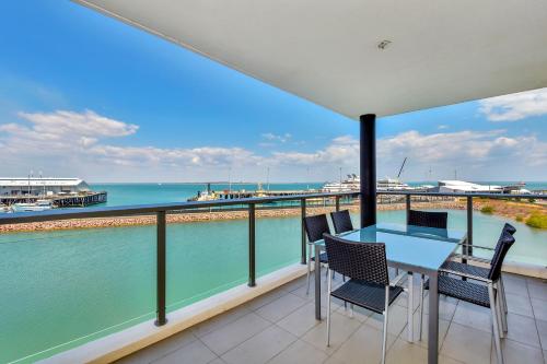 a dining room with a balcony overlooking the ocean at Darwin Waterfront Short Stay Apartments in Darwin