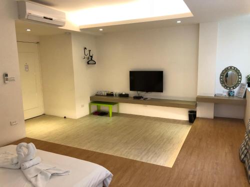 uma sala de estar com uma televisão de ecrã plano na parede em Happiness Dot em Tamsui
