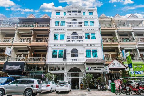 a tall white building with cars parked in front of it at Grand Elevation Hotel in Phnom Penh