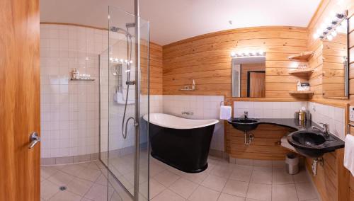 a bathroom with a shower and a sink and a tub at Westwood Lodge in Franz Josef