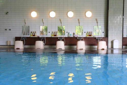 a swimming pool with blue water in a building at Bosenkan in Gero