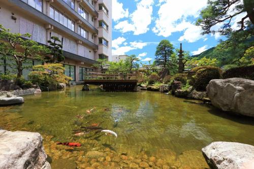 um lago de carpas em frente a um edifício em Bosenkan em Gero