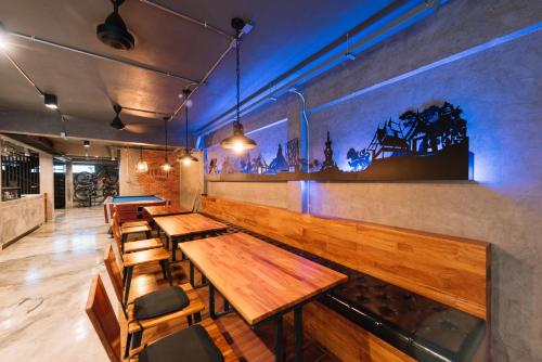 a row of wooden tables and chairs in a restaurant at Bed & Bike Hostel in Chiang Rai