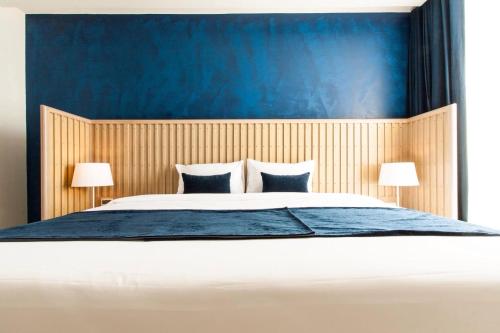 a bedroom with a large bed with a blue headboard at Klub Hotel Bangkok in Bangkok