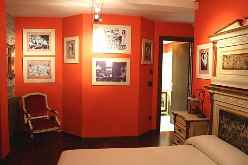 a bedroom with orange walls and a bed and a fireplace at Casona El Gurugu in Luarca