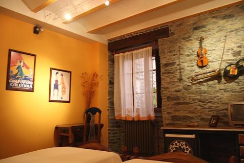 a bedroom with a bed and a stone wall at Casona El Gurugu in Luarca