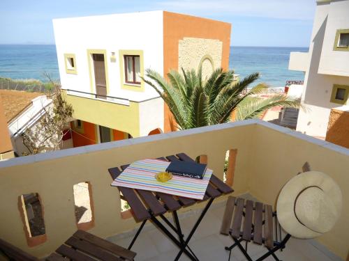 a table and chairs on a balcony overlooking the ocean at Almyra Apartments & Suites in Sfakaki