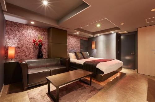 a hotel room with a bed and a couch at HOTEL LOVE in Nagoya