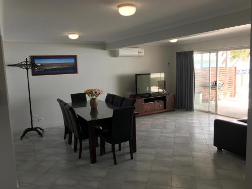 a dining room with a table and chairs and a television at Beachside & Jetty View Apartment 6 - Captain's Apt in Streaky Bay