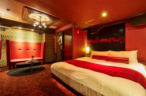 a hotel room with a large bed and a chandelier at HOTEL LOVE in Nagoya