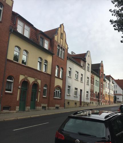 a car parked in front of a row of buildings at Gemütliche Ferienwohnung im Erdgeschoss- Jenaer Straße in Erfurt