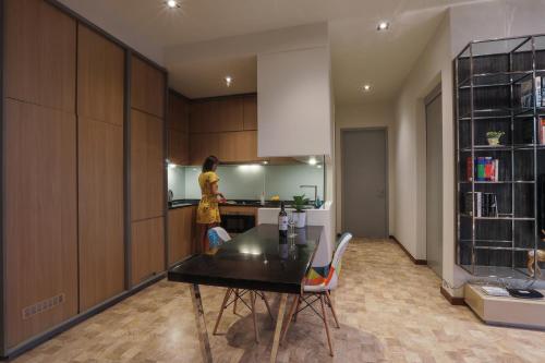 a woman standing in a kitchen with a table at Expressionz Suites By iHost Global in Kuala Lumpur