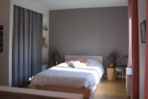 Schlafzimmer mit einem Bett mit weißer Bettwäsche in der Unterkunft Ker spa, gite avec spa privatif dans la chambre in Dol-de-Bretagne